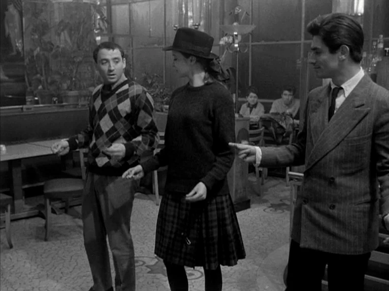 Band of Outsiders (Bande à part) (1964) movie still: fullbody — A mid-century modern interior space with tiled floors and glass partitions. Two men…