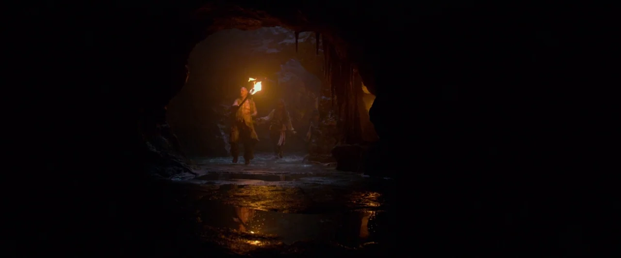 Pirates of the Caribbean: On Stranger Tides movie still: wide — A wide, dark natural cavern features standing water that reflects the torchlight.…