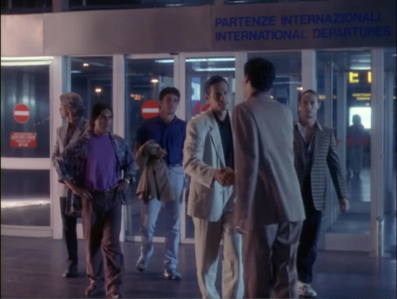 Code Name: Wolverine (1996) movie still: fullbody — A group of five men congregate in front of an international airport terminal entrance. They are…