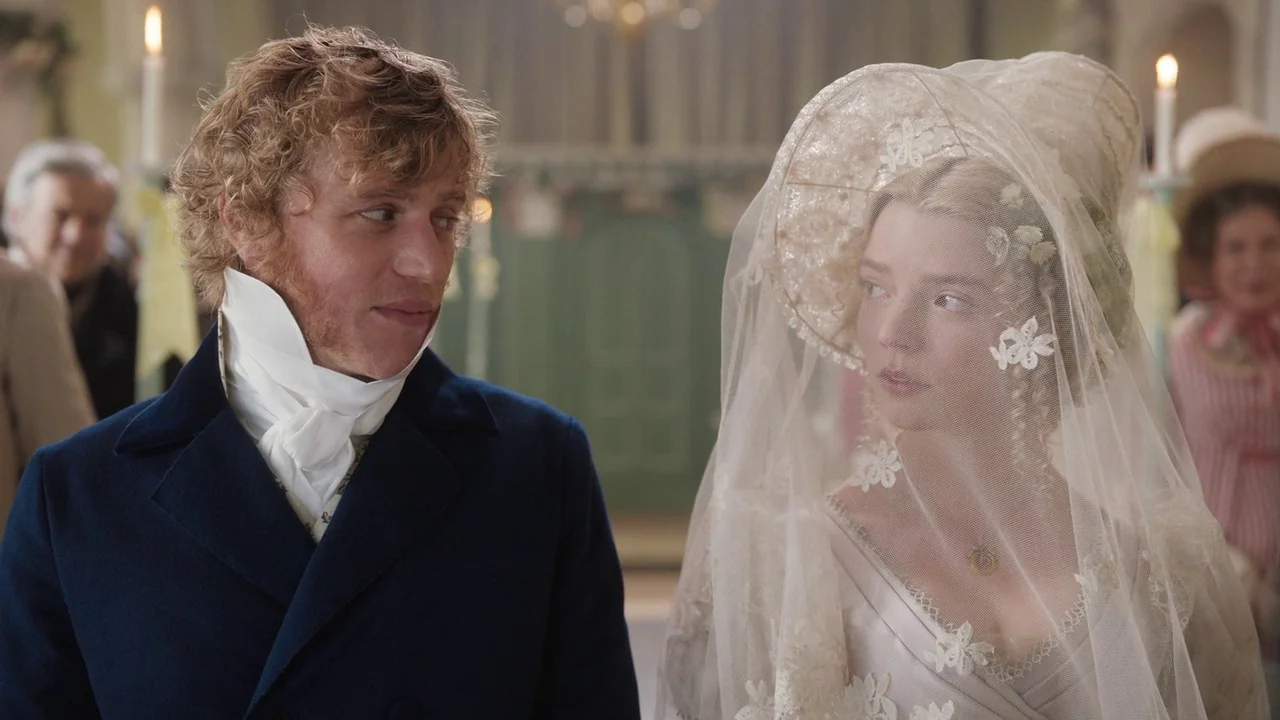 Emma. (2020) movie still: medium — An interior of a 19th-century church with ornate architecture and soft daylight streaming in. A man in a dark…