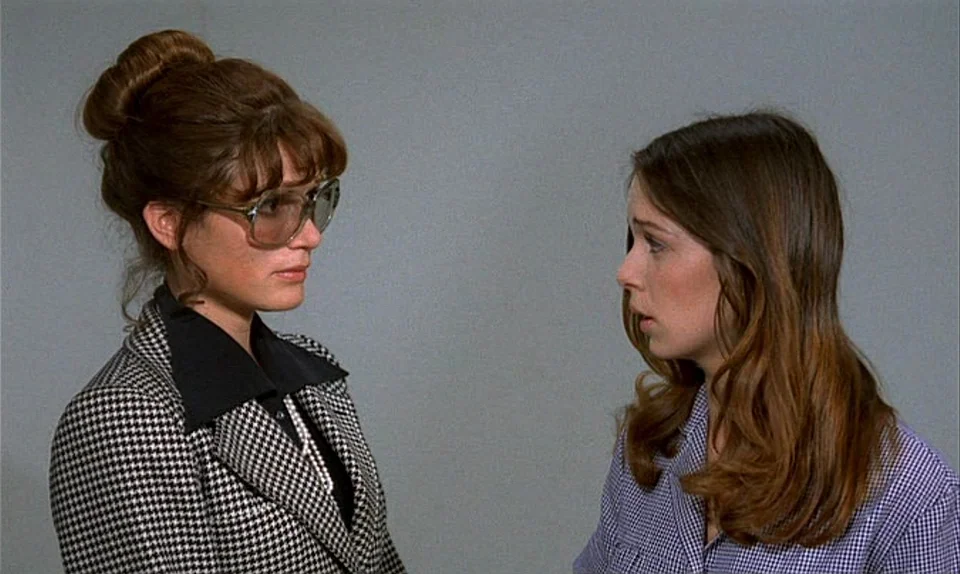 Successive Slidings of Pleasure (Glissements progressifs du plaisir) (1974) movie still: medium — A plain gray wall serves as the backdrop for two…