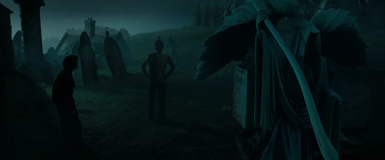 Harry Potter and the Goblet of Fire (2005) movie still: wide — A dark, expansive cemetery at night features numerous stone monuments under a gloomy…