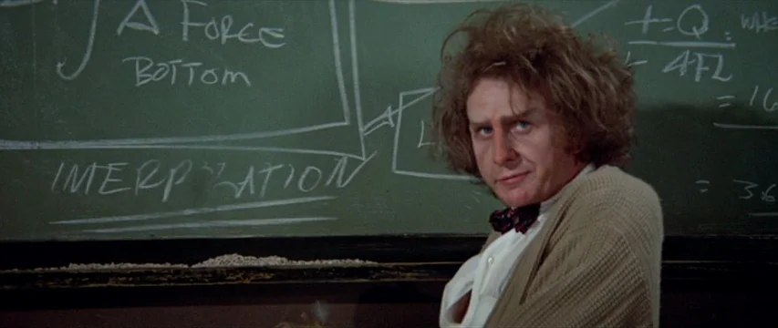 Brewster McCloud (1970) movie still: medium — A professor stands before a green blackboard covered in handwritten mathematical formulas and notes.…
