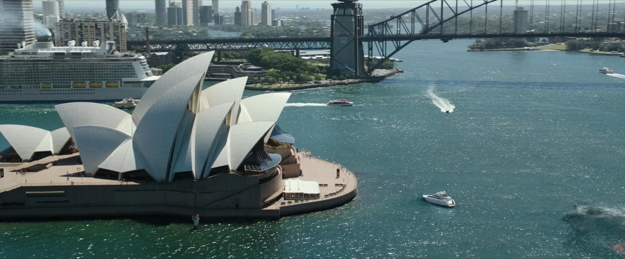 Pacific Rim: Uprising (2018) movie still: establishing — An aerial view of a large white landmark building situated on a peninsula. Multiple vessels…