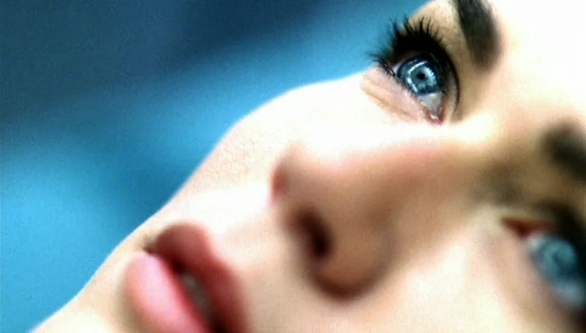 Maelström (2000) movie still: closeup — A close-up view shows a woman's face tilted upward in soft blue light. Her blue eyes are wide open while she…