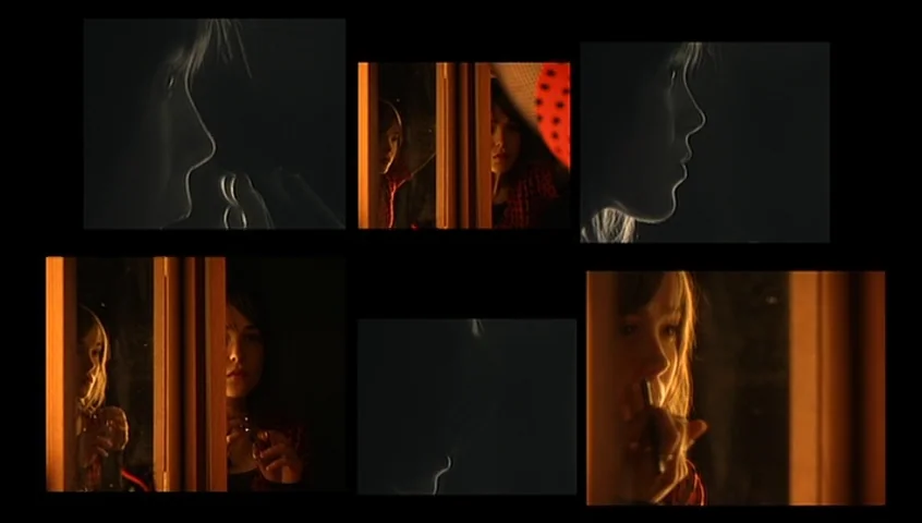 The Tracey Fragments (2007) movie still: closeup — A dark, partitioned space is illuminated by a warm, side-facing light source. A young woman uses…