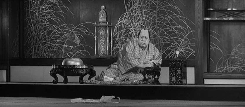 Red Beard (1965) movie still: medium — A traditional Japanese interior features a painted screen mural of grasses behind a dais. A man in a kimono…