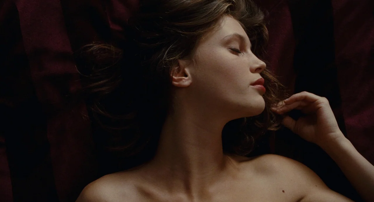 Young & Beautiful (2013) movie still: closeup — A woman lies on a deep red textured surface. She rests with her eyes closed.