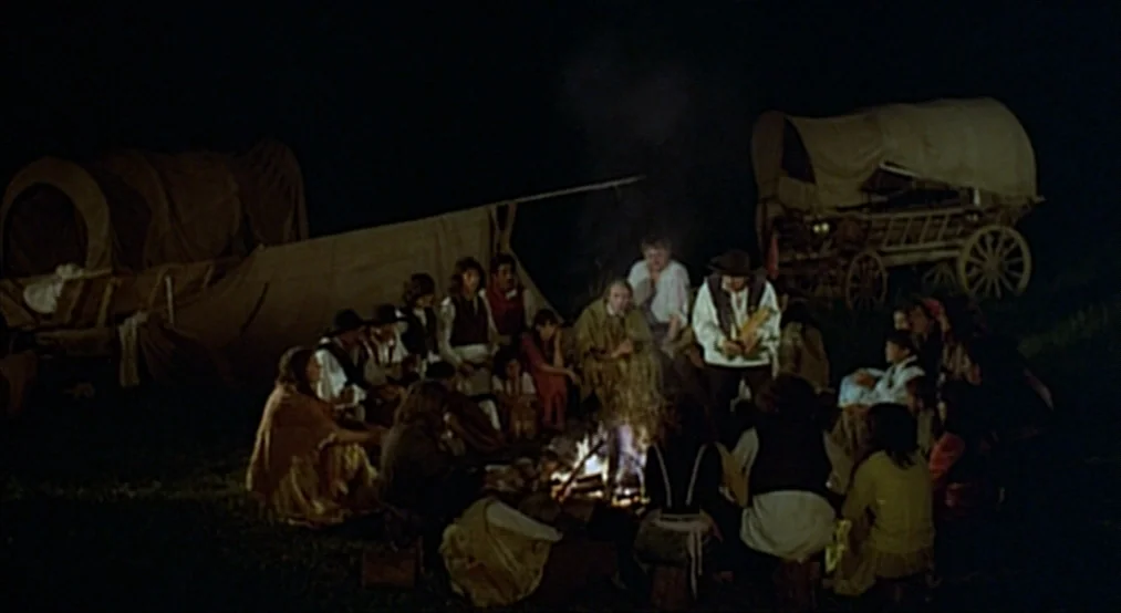 Nosferatu the Vampyre (Nosferatu Phantom Der Nacht) (1979) movie still: wide — A group of people sits around a campfire at night near two covered…