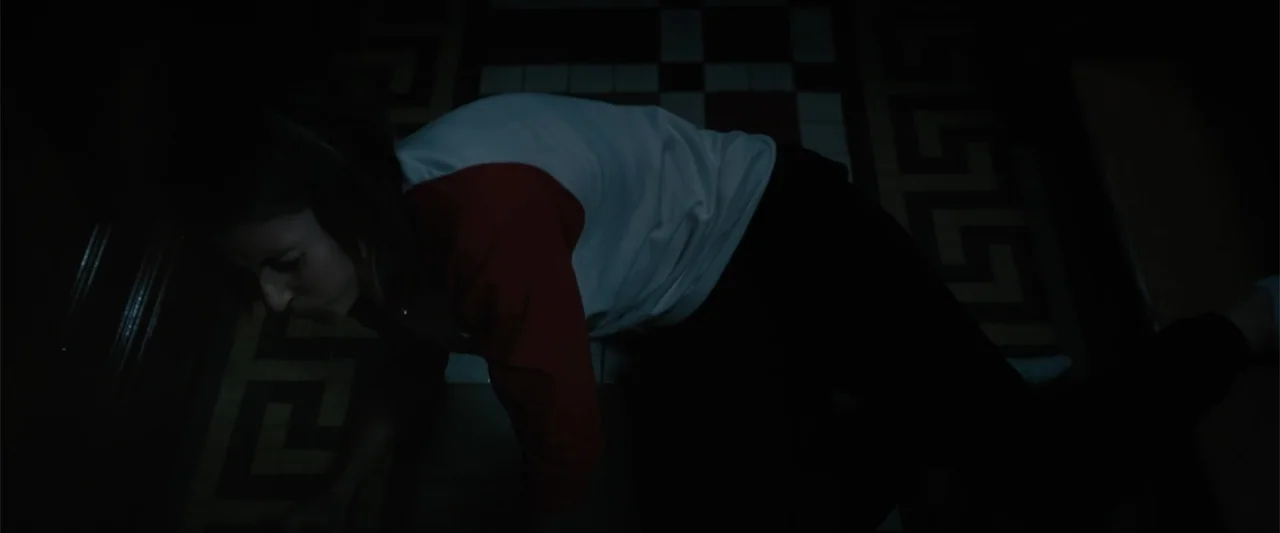 Equation of Love and Tone Deafness (2015) movie still: medium — A dark interior space features a floor with a distinct greek key geometric tile…