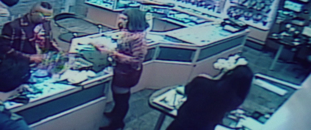 Uncut Gems (2019) movie still: wide — A high-angle view of a retail space with glass counters and scattered inventory items. Three figures stand…