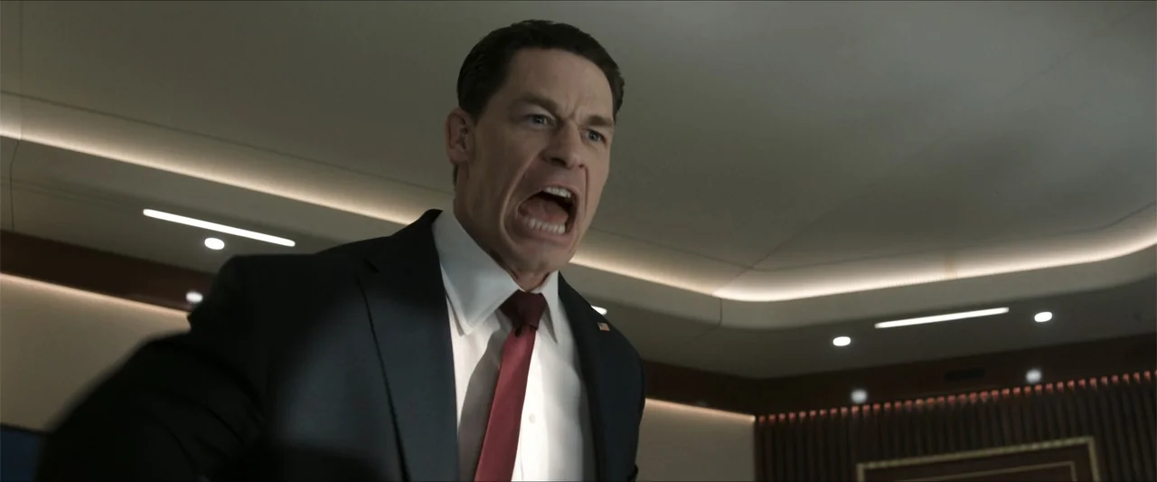 Heads of State (2025) movie still: medium — A modern office environment features recessed cove lighting and minimalist architectural wall paneling.…