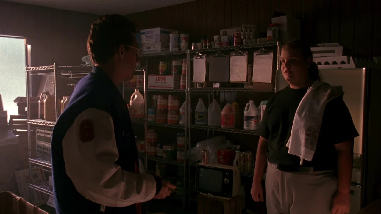 Jason Goes To Hell (1993) movie still: medium — A cluttered storage room features metal shelves packed with canned goods and supplies. A man in a…
