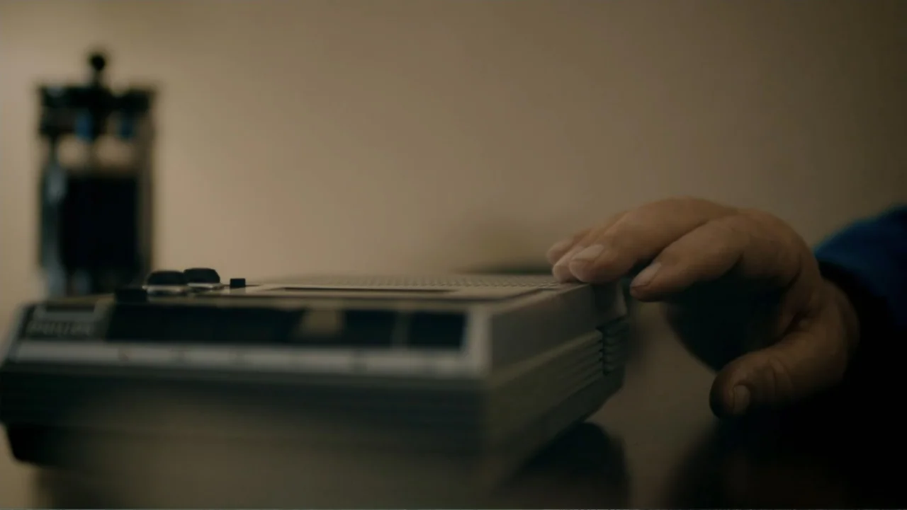 Aileen Wuornos : Mind of a Monster (2020) movie still: closeup — A dimly lit room contains a portable electronic recorder placed on a flat surface.…