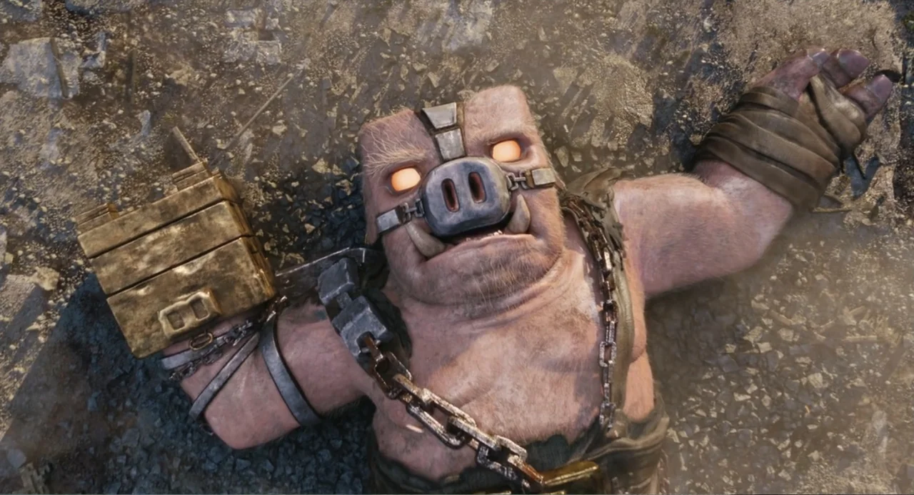 A Minecraft Movie (2025) movie still: medium — A humanoid pig creature lies flat on jagged rocky terrain under bright daylight. The muscular subject…