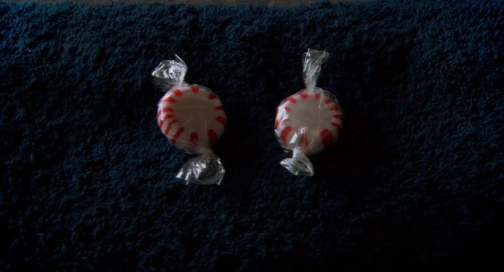 Me and You and Everyone We Know (2005) movie still: closeup — Two peppermint candies sit on a dark blue textured towel surface. The round candies…