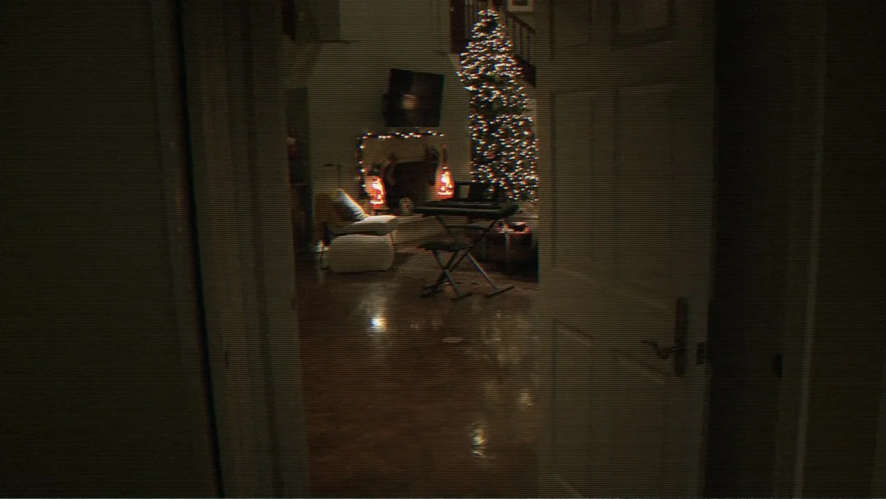 Paranormal Activity: The Ghost Dimension (2015) movie still: wide — A dimly lit room viewed through a slightly open wooden door. A decorated…