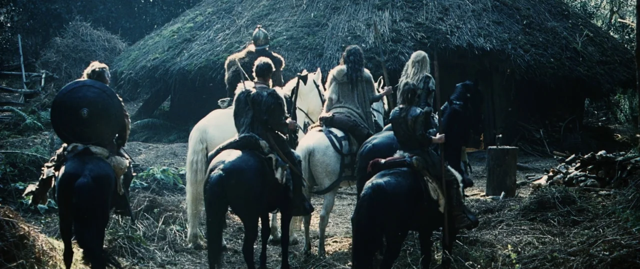 Centurion (2010) movie still: wide — A group of mounted warriors on dark and white horses faces a primitive thatched hut. The riders are equipped…