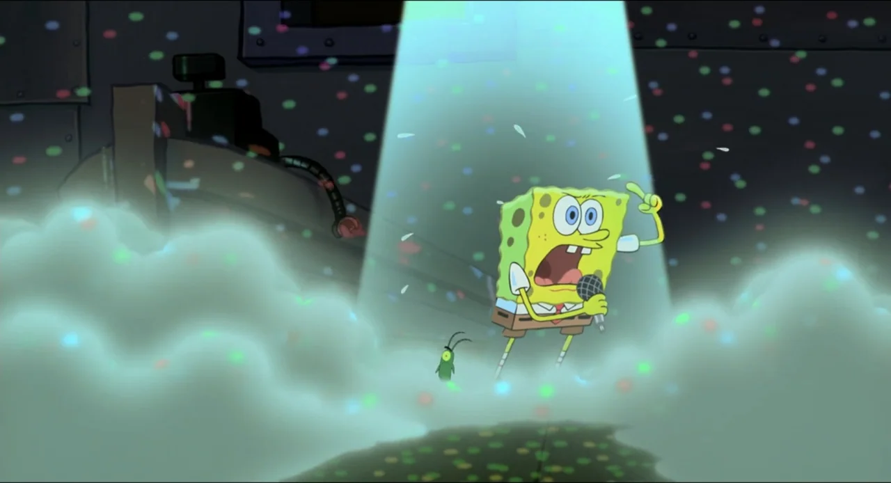 The SpongeBob SquarePants Movie (2004) movie still: medium — A yellow sea sponge stands on a stage floor under a bright spotlight. Confetti falls…