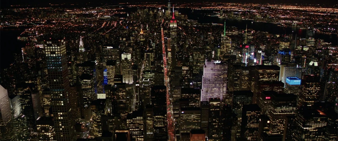 Collateral Beauty (2016) movie still: establishing — A sprawling aerial view of the New York City skyline at night. Countless illuminated skyscraper…