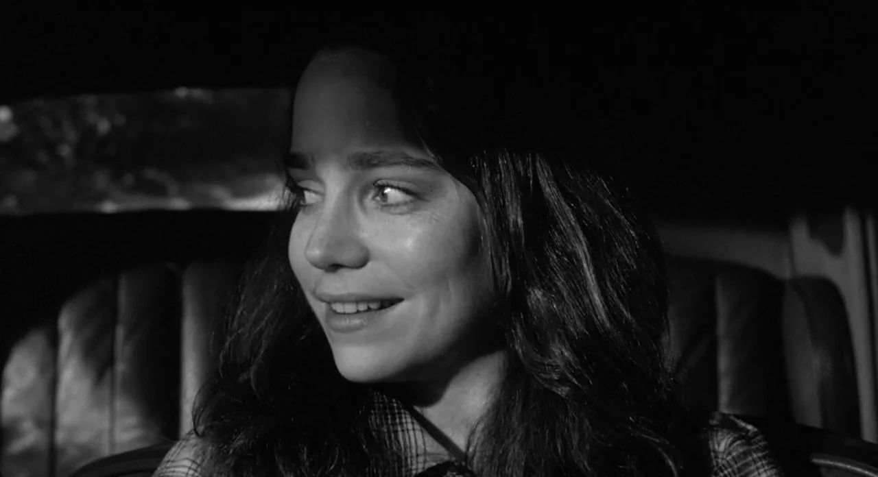 Stardust Memories (1980) movie still: closeup — A dark vehicle interior with leather headrests visible behind the subject. A woman looks to the side…