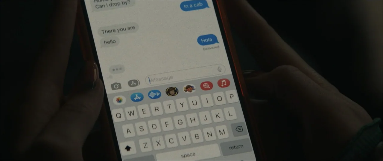 Daddio (2024) movie still: closeup — A close-up view shows a smartphone screen displaying a messaging application interface. The user is in the…
