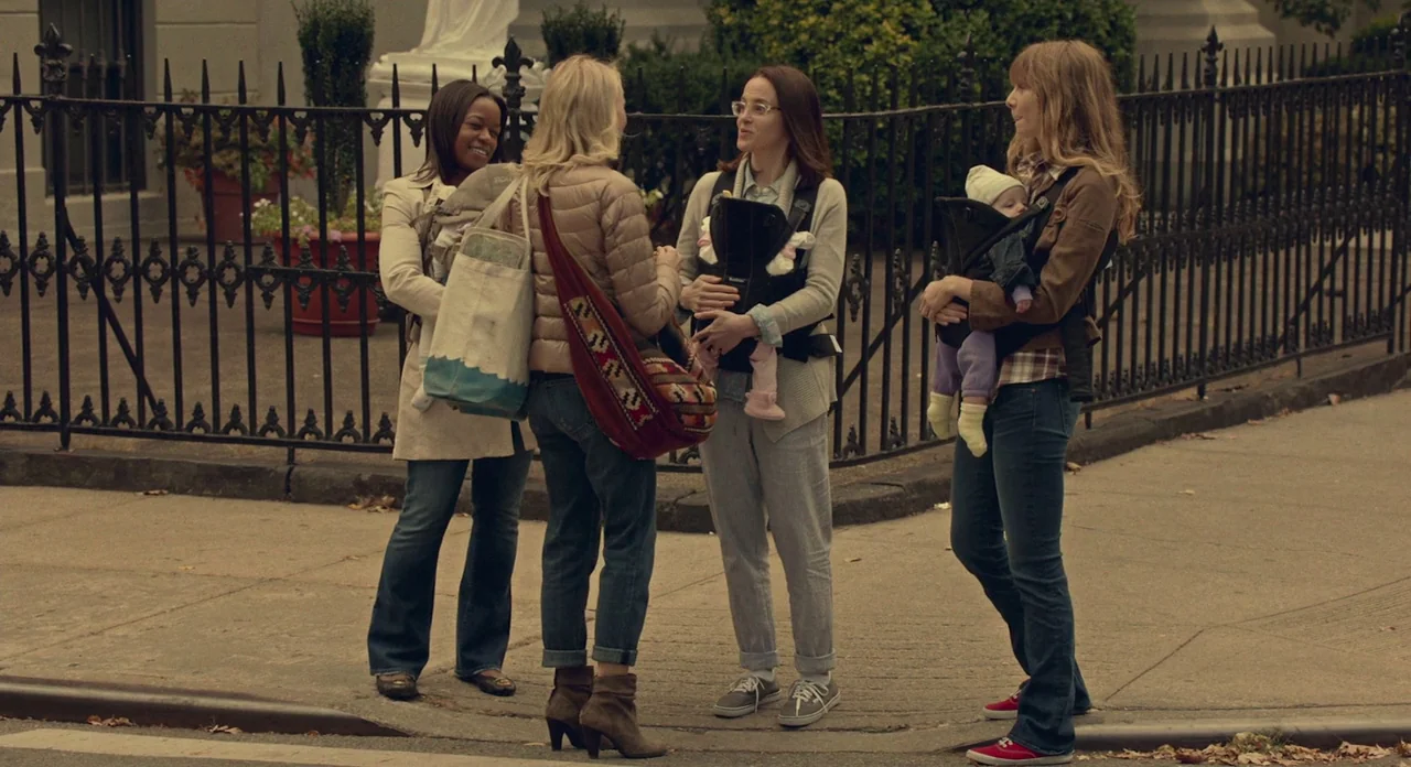 While We’re Young (2014) movie still: fullbody — A group of women with infants in carriers congregate on a paved city sidewalk. They are gathered…