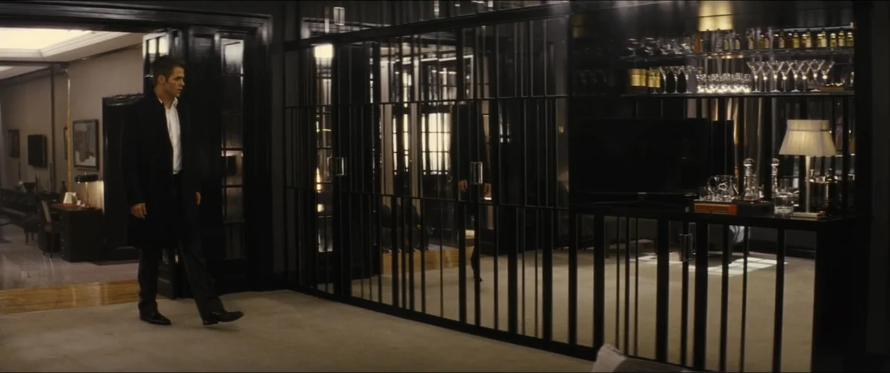 Jack Ryan: Shadow Recruit (2014) movie still: fullbody — A contemporary apartment interior features dark wood paneling, floor-to-ceiling metal…