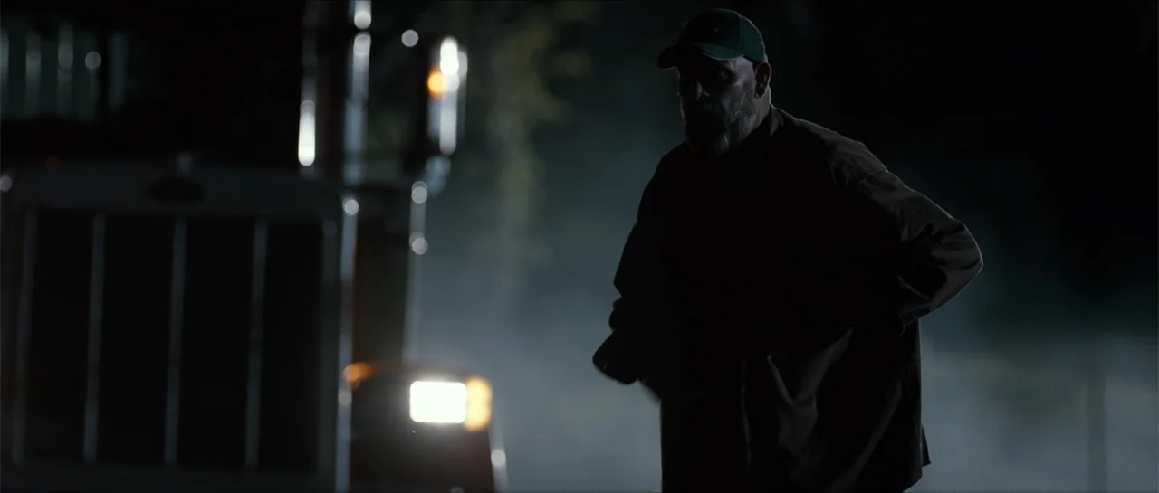 Jeepers Creepers 3 (2017) movie still: medium — A dark night setting features a large truck stopped with its headlight shining brightly. A man…