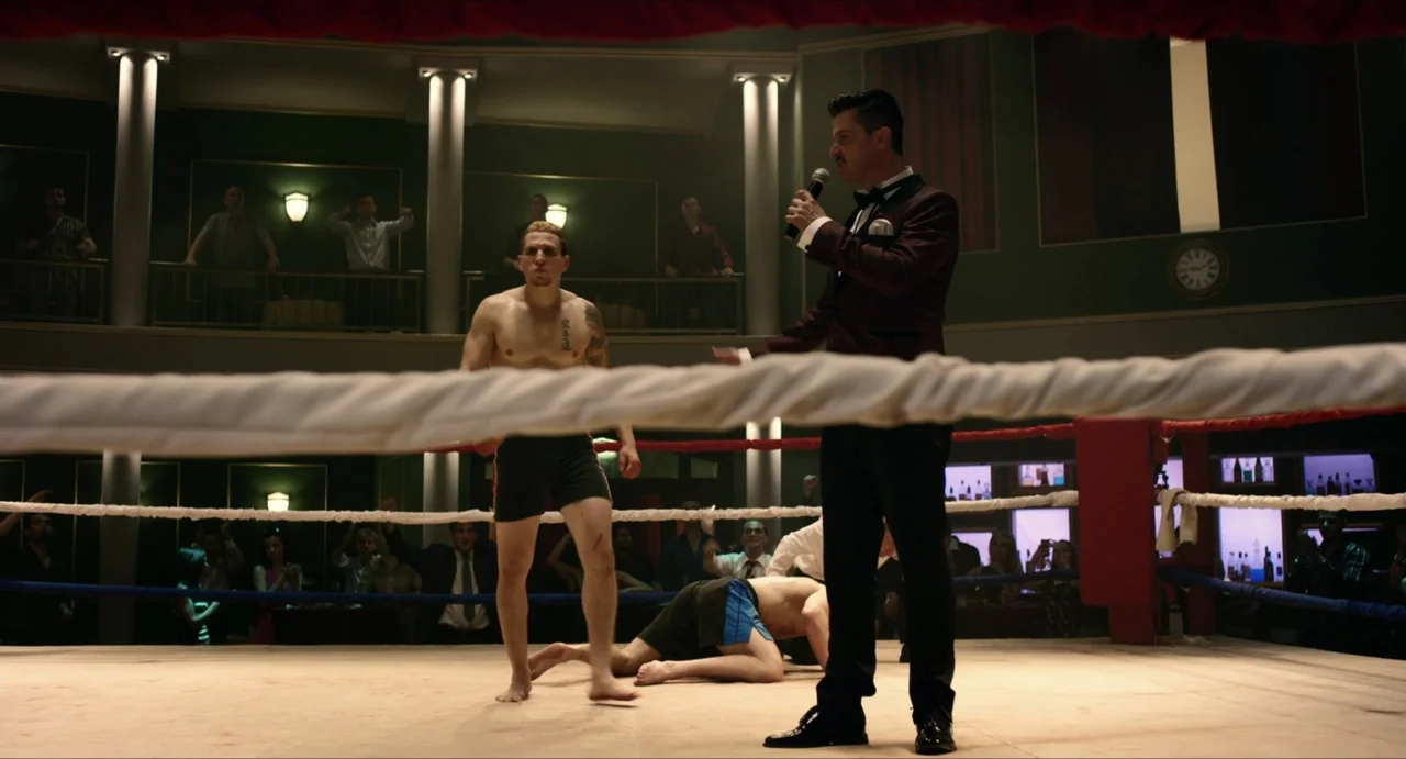 Boyka: Undisputed IV (2016) movie still: fullbody — An indoor venue featuring a central ring surrounded by a balcony with audience members. A…