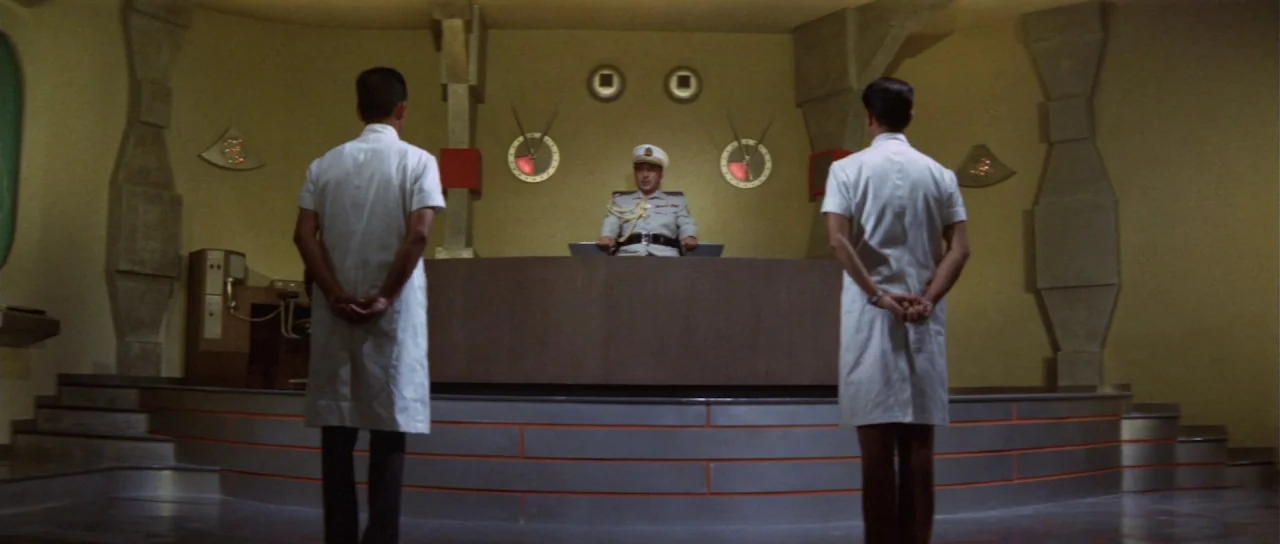 Ebirah Horror of the Deep (1966) movie still: wide — A modernist command center features tiered levels, geometric wall carvings, and circular…
