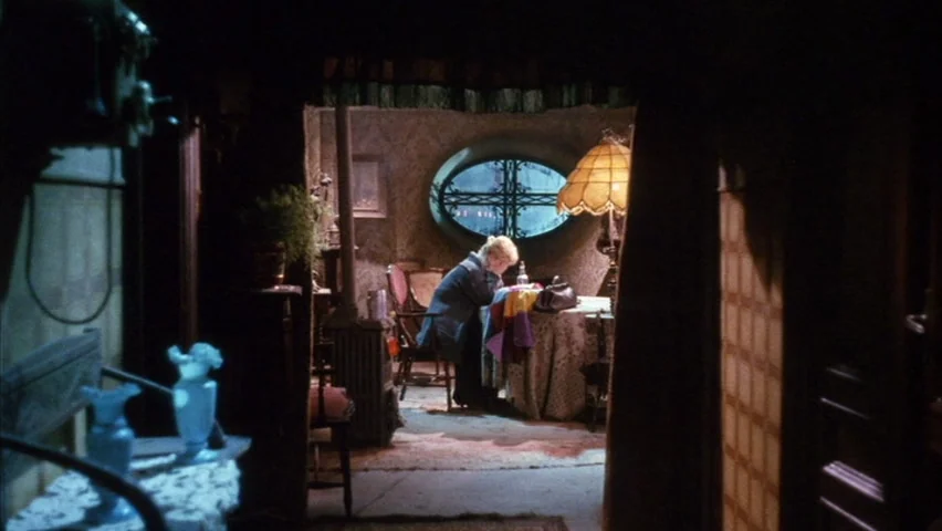 Black Sabbath (1963) movie still: medium — An interior space viewed through a doorway reveals a cluttered, dimly lit sitting room. A lone woman sits…