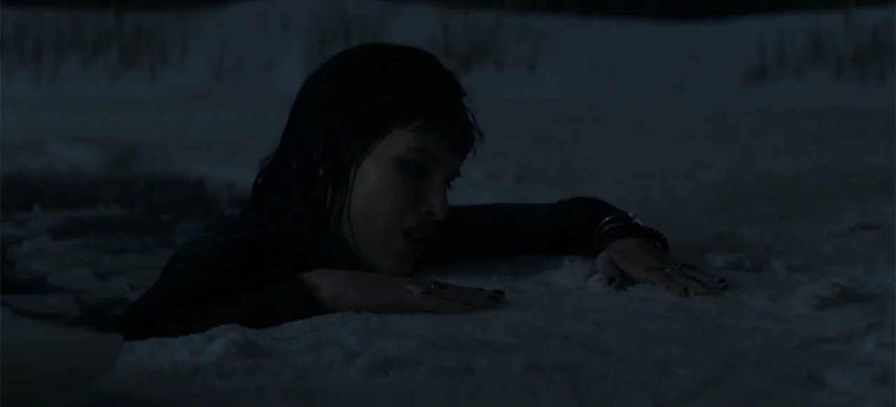 I Still See You (2018) movie still: medium — A dark, snow-covered ground under a night sky with no visible artificial light sources. A young woman…