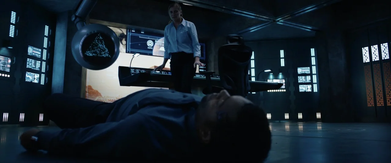 2036 Origin Unknown (2018) movie still: medium — A dark futuristic spaceship control deck features illuminated consoles and a robotic mechanical…