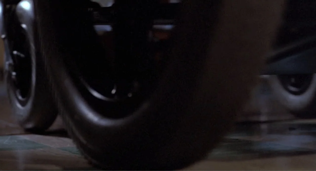 An Experiment in Fear: The Making of Monkey Shines (2014) movie still: closeup — A close perspective captures a thick black rubber tire rolling on…