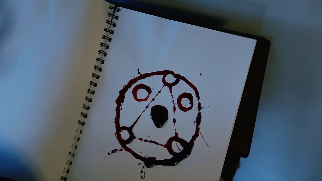 The Deeper You Dig (2019) movie still: closeup — A spiral-bound sketchbook lies open on a dark surface under cool ambient light. A hand-drawn…