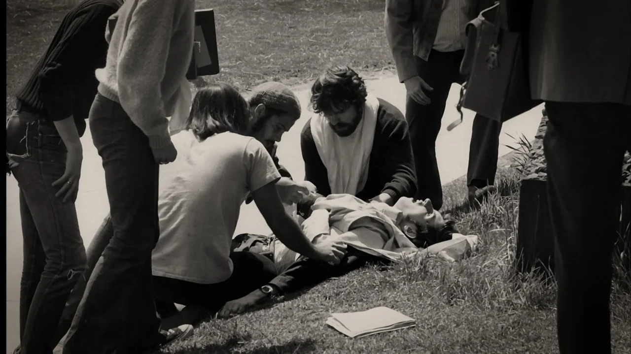 Breslin and Hamill: Deadline Artists (2018) movie still: medium — A group of young men in 1970s attire gather on a grassy patch. They kneel around…