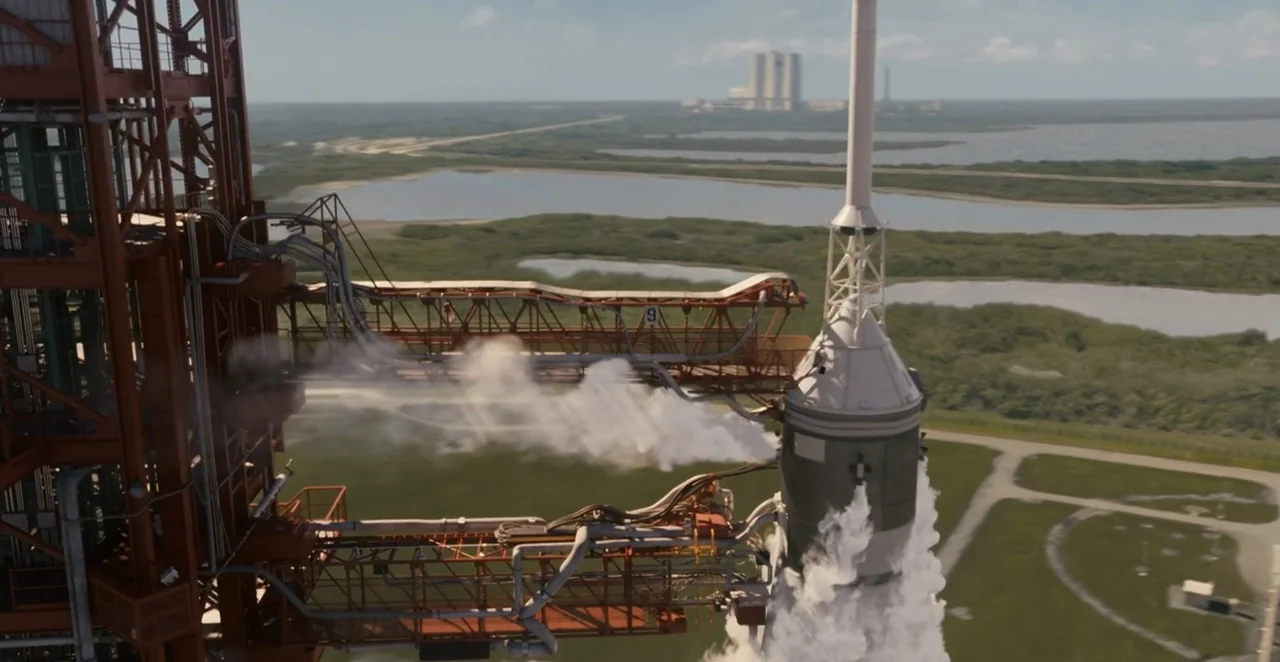 Men in Black 3 (2012) movie still: wide — A tall white rocket stands connected to a massive red metal launch gantry. The facility is surrounded by…