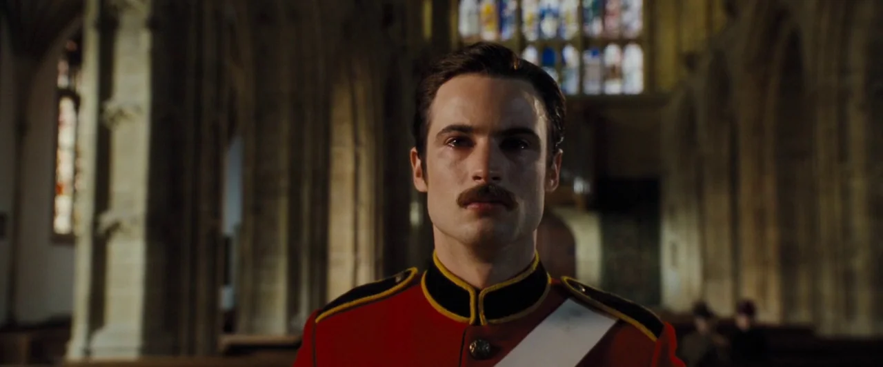 Far from the Madding Crowd (2015) movie still: medium — A stone church interior with blurred stone arches and stained glass in the distance. A man…