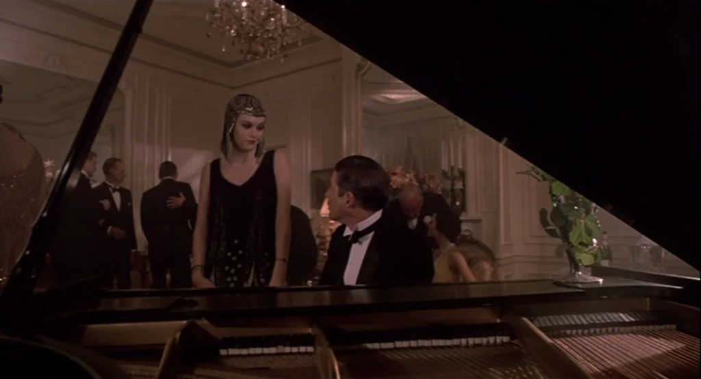 The Cotton Club (1984) movie still: medium — An opulent 1920s ballroom features guests in formal attire among gold-trimmed white walls. A woman in a…