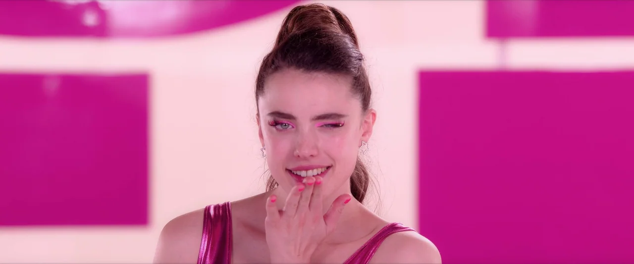 The Substance (2024) movie still: closeup — A brightly lit studio space features magenta square graphic elements on a white background. A woman in a…