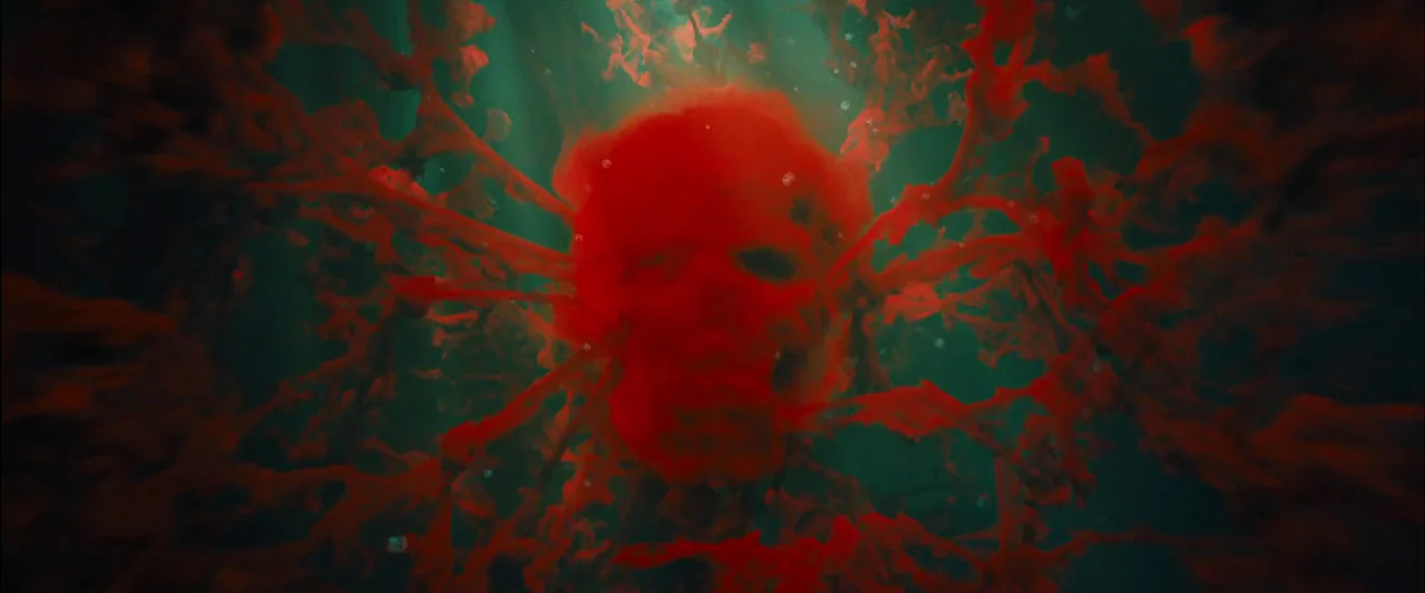 Skyfall (2012) movie still: closeup — A dark underwater environment contains a skull-shaped mass of red tendrils and matter. The red organic…