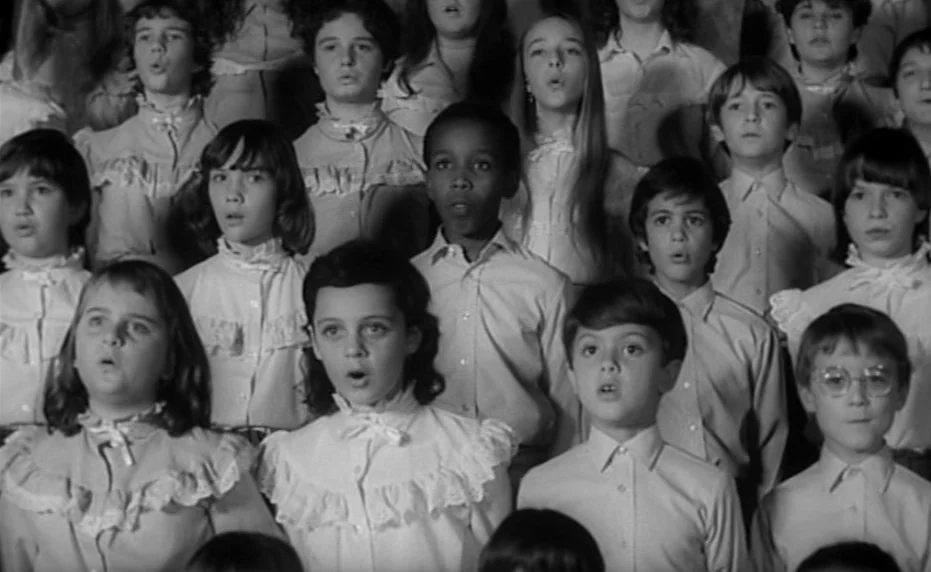 Vivement Dimanche (1983) movie still: medium — A large group of children arranged in rows for a choral performance. The children sing with mouths…