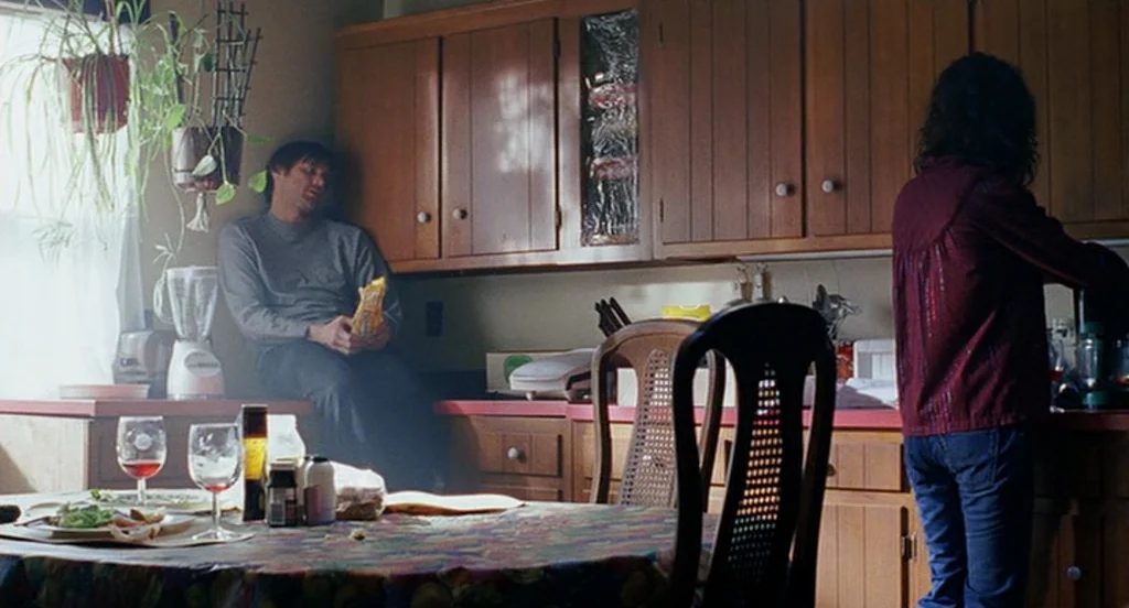 Eternal Sunshine of the Spotless Mind (2004) movie still: medium — A residential kitchen features honey-oak cabinetry and a floral pattern…