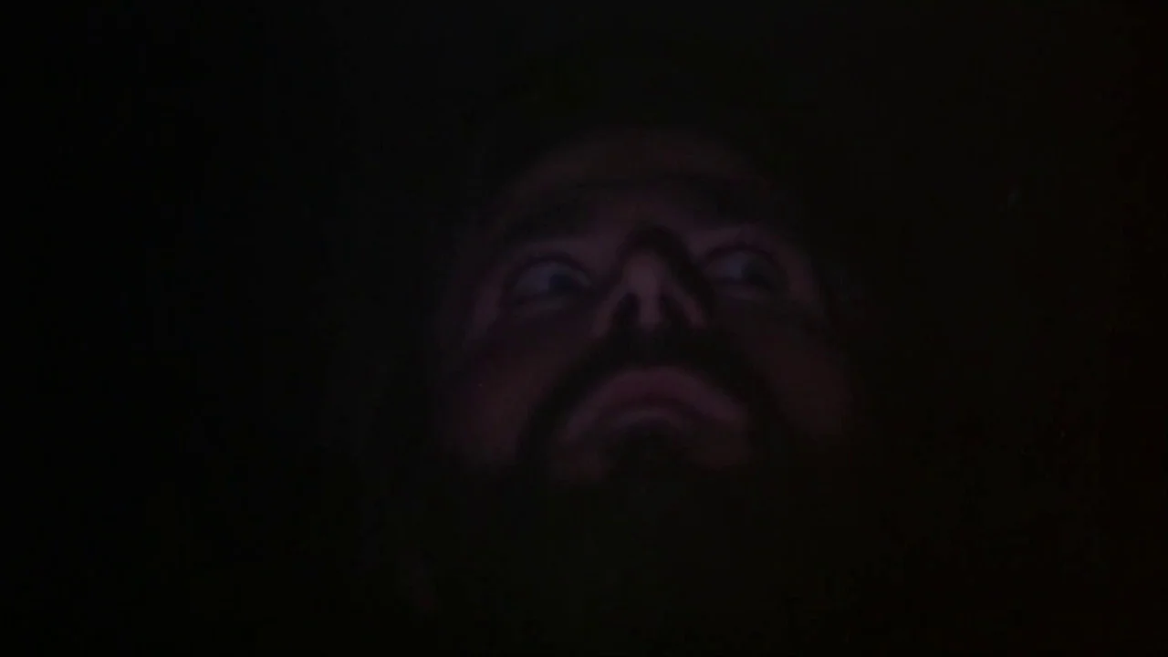 A Quiet Place In The Country (1968) movie still: closeup — A man's face emerges from total darkness, lit by an unseen low light source. The man…