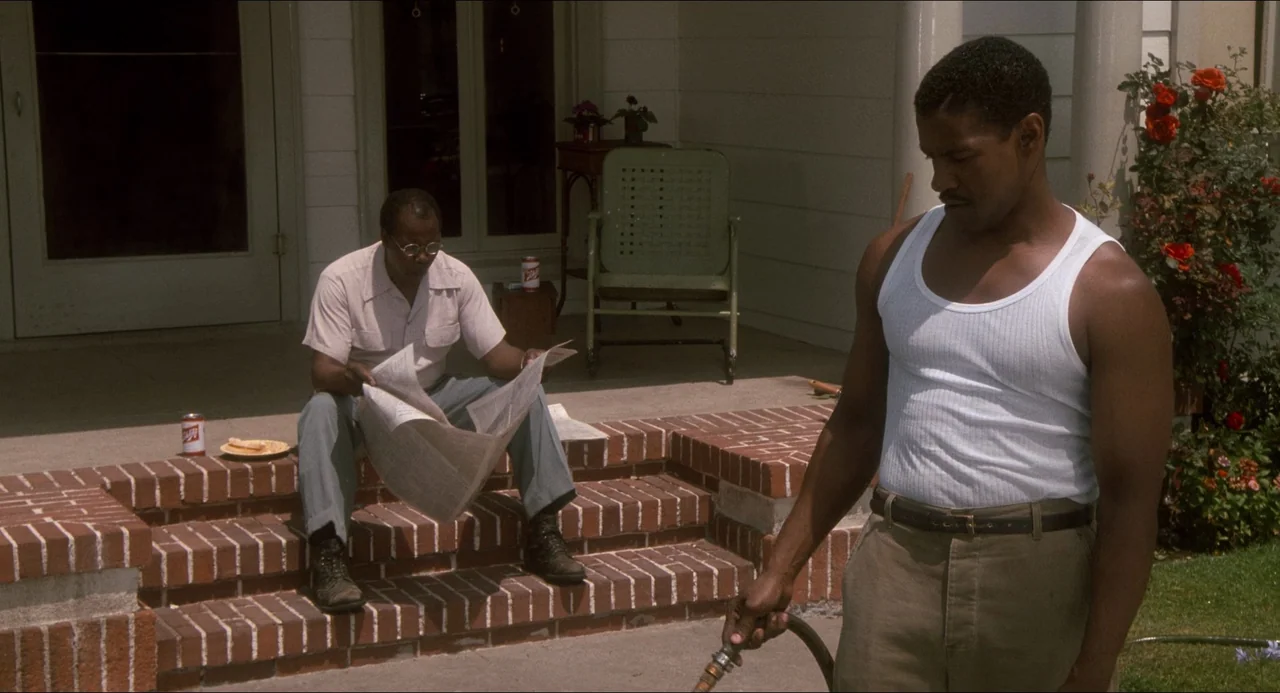 Devil In A Blue Dress (1995) movie still: fullbody — A residential concrete porch features red brick steps leading to a white front door. One man…