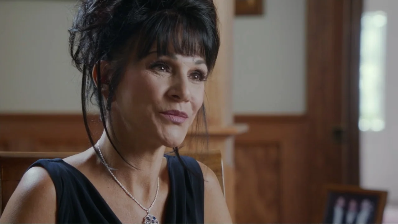 At the Heart of Gold: Inside the USA Gymnastics Scandal (2019) movie still: closeup — An interior space features wood paneled walls and a soft-focus…