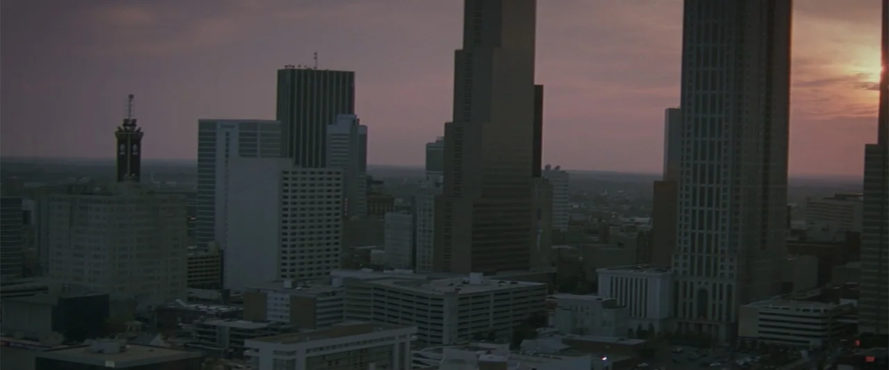 Maxine's Baby: The Tyler Perry Story (2023) movie still: establishing — An aerial view captures a dense urban city skyline during the evening hours.…