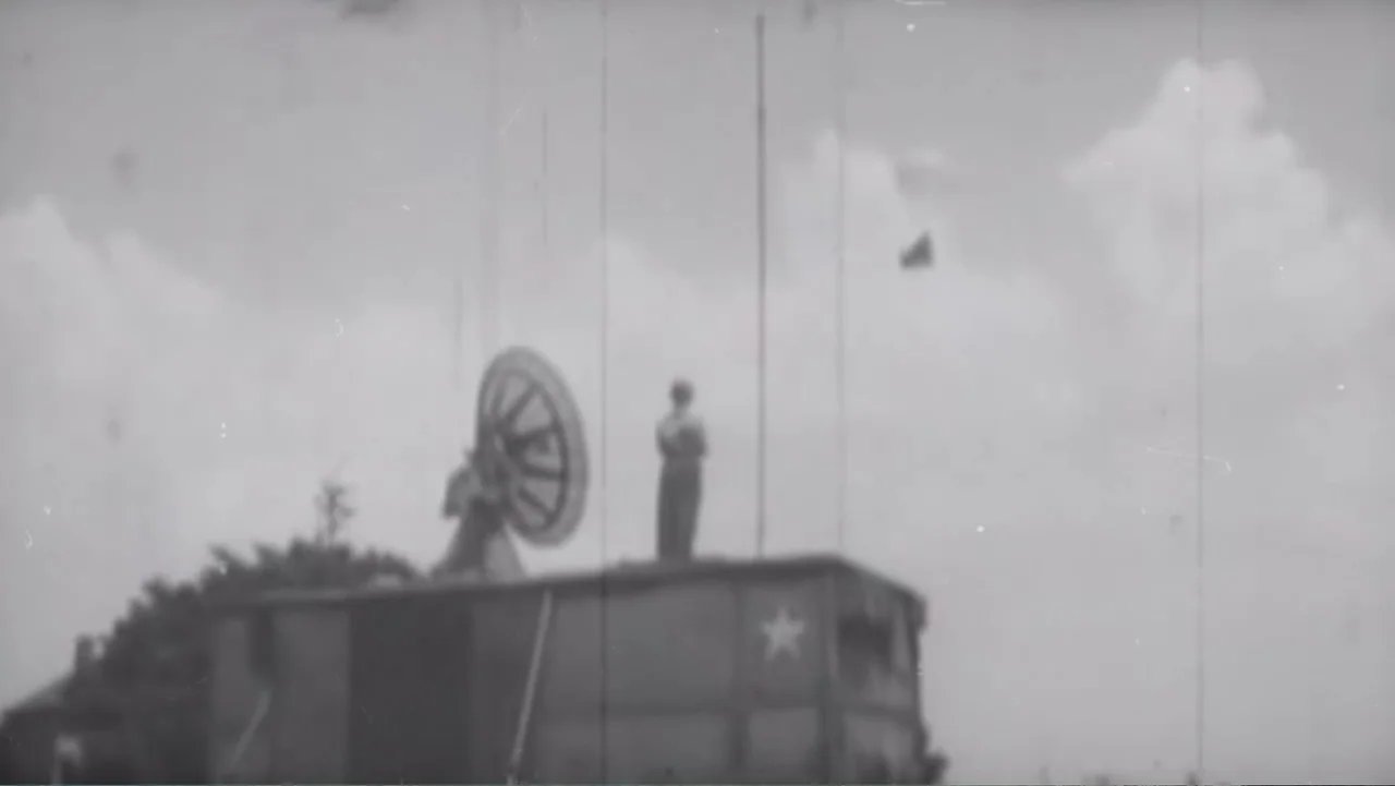 UFO Conspiracies: The Hidden Truth (2020) movie still: wide — A military vehicle with a painted star stands against a bright, overcast sky. A single…