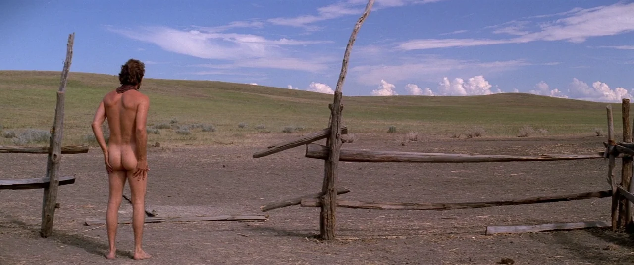 Dances With Wolves (1990) movie still: fullbody — A vast, open plain with rolling hills under a bright blue sky. A man stands nude by a broken…